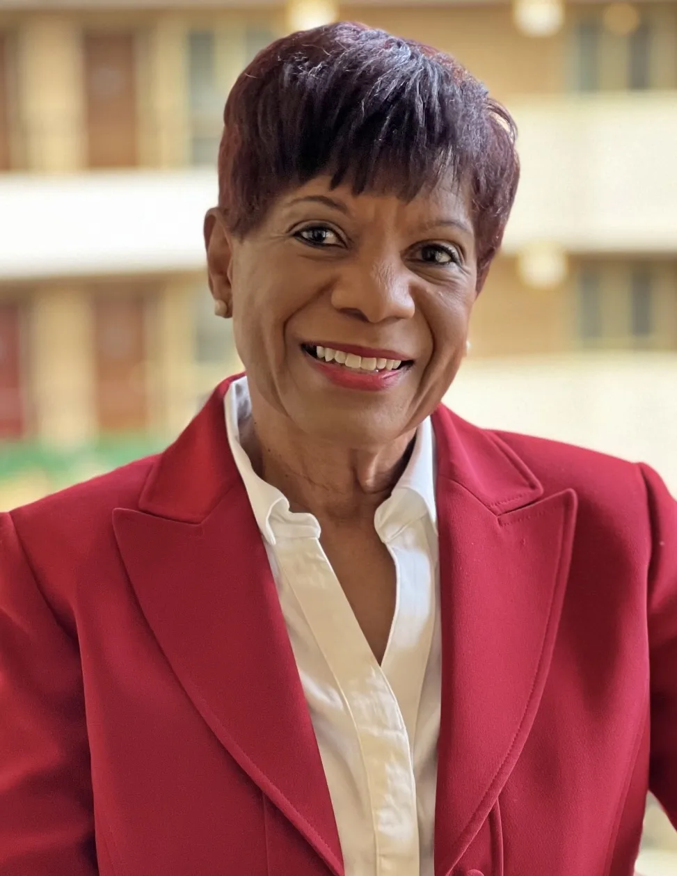 Joyce Bell Winkler smiles in a professional portrait wearing a red blazer.