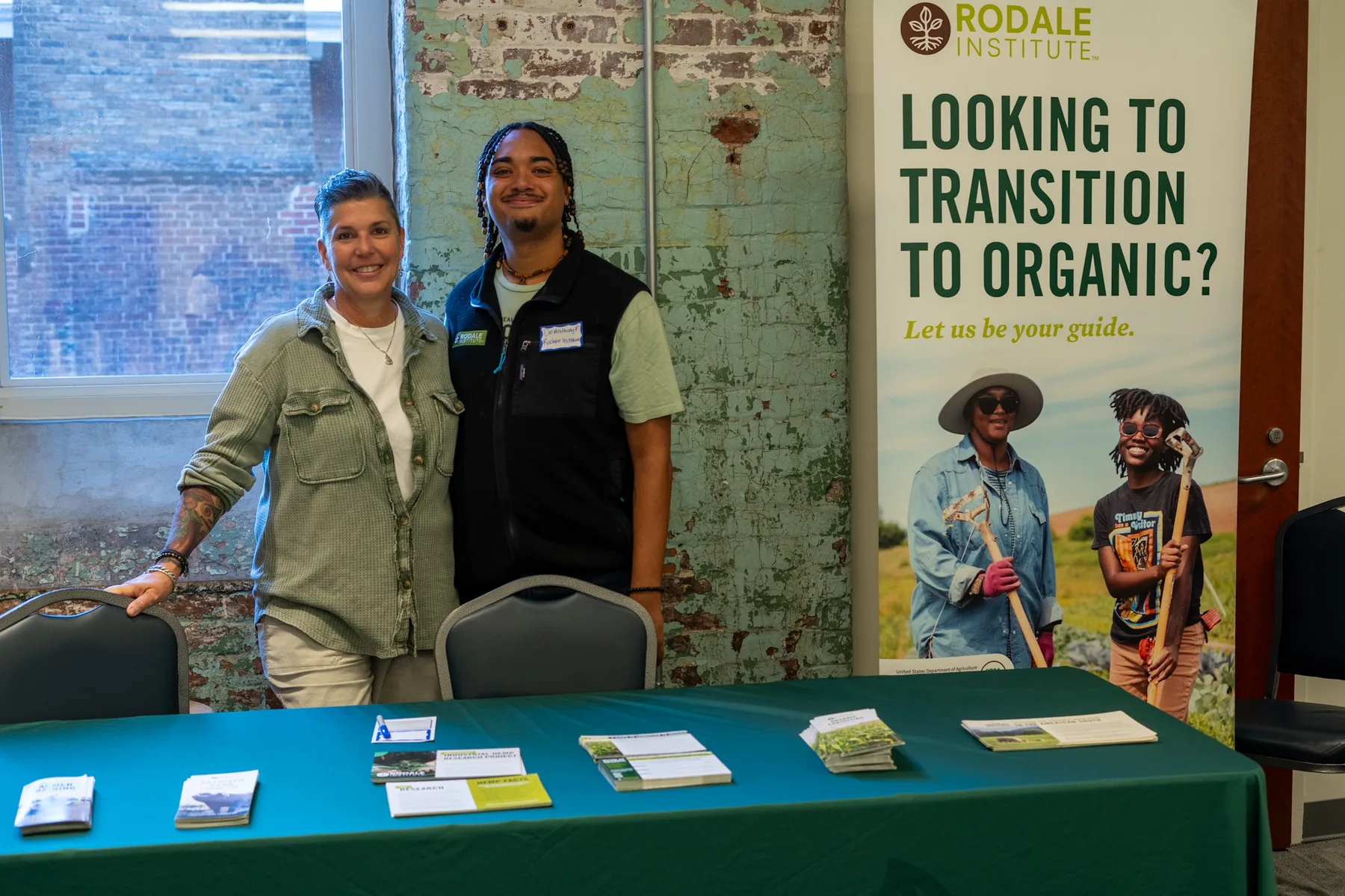 Two people stand together at an agricultural information booth.