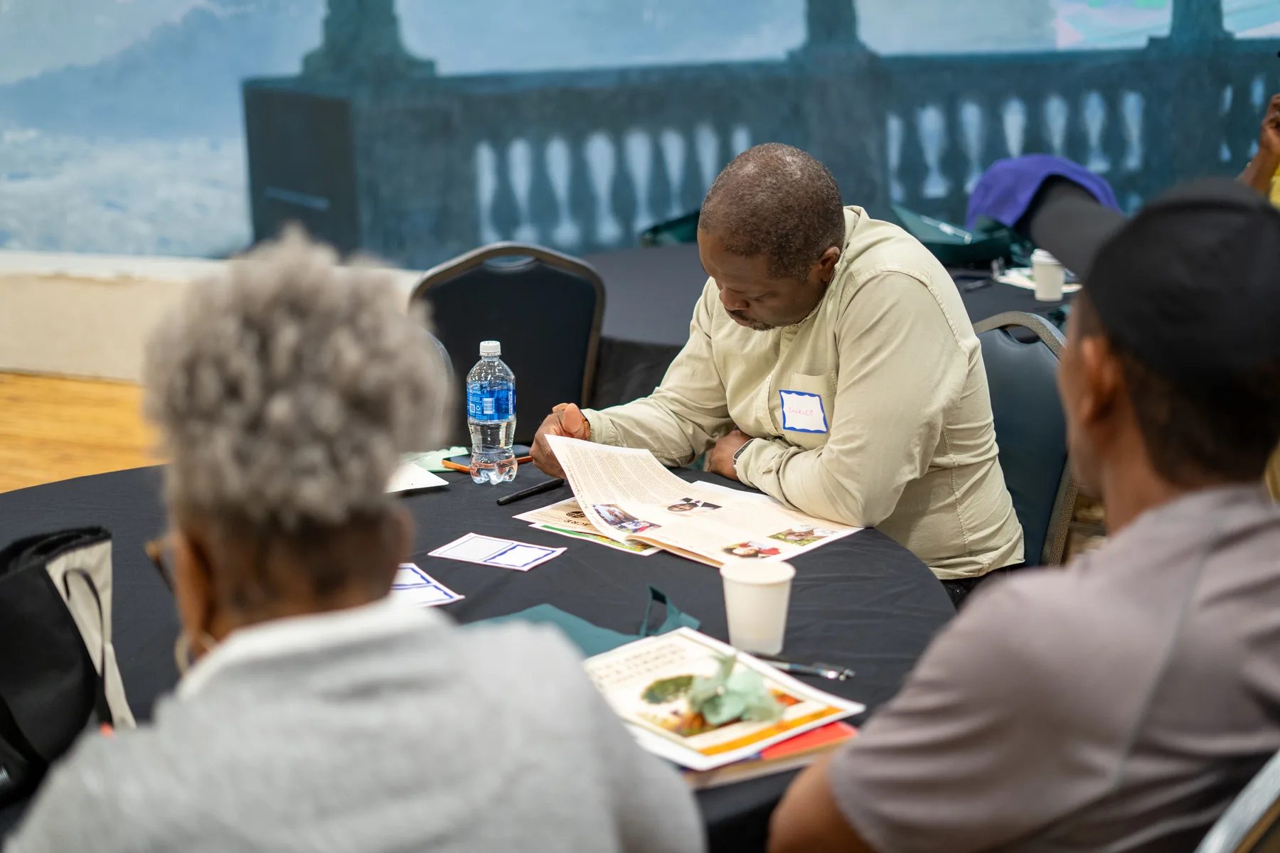 People work through printed materials together at a table.