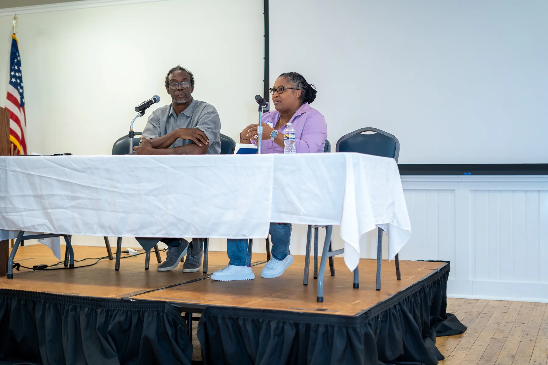 Panelists speak from the front of a gathering.