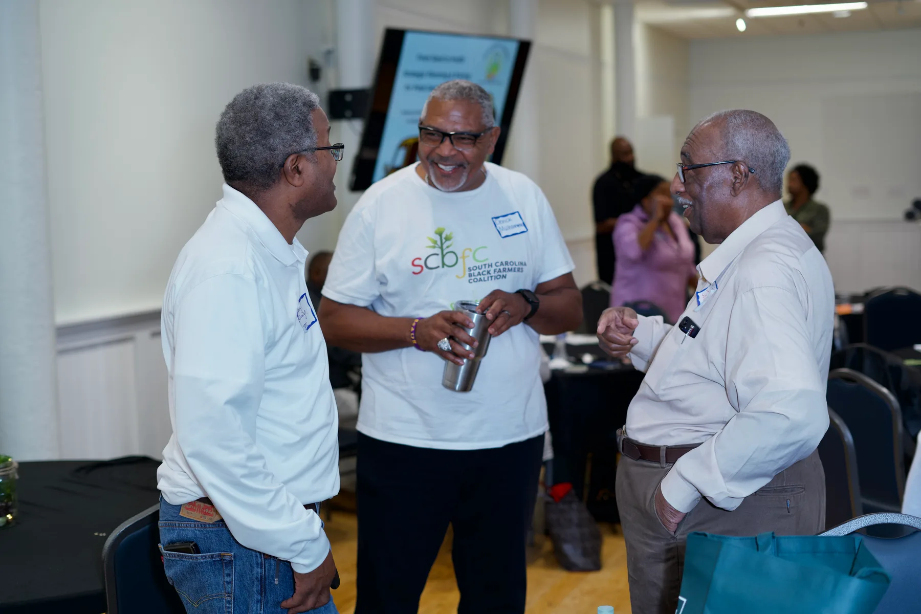 Three people talk together during a community gathering.